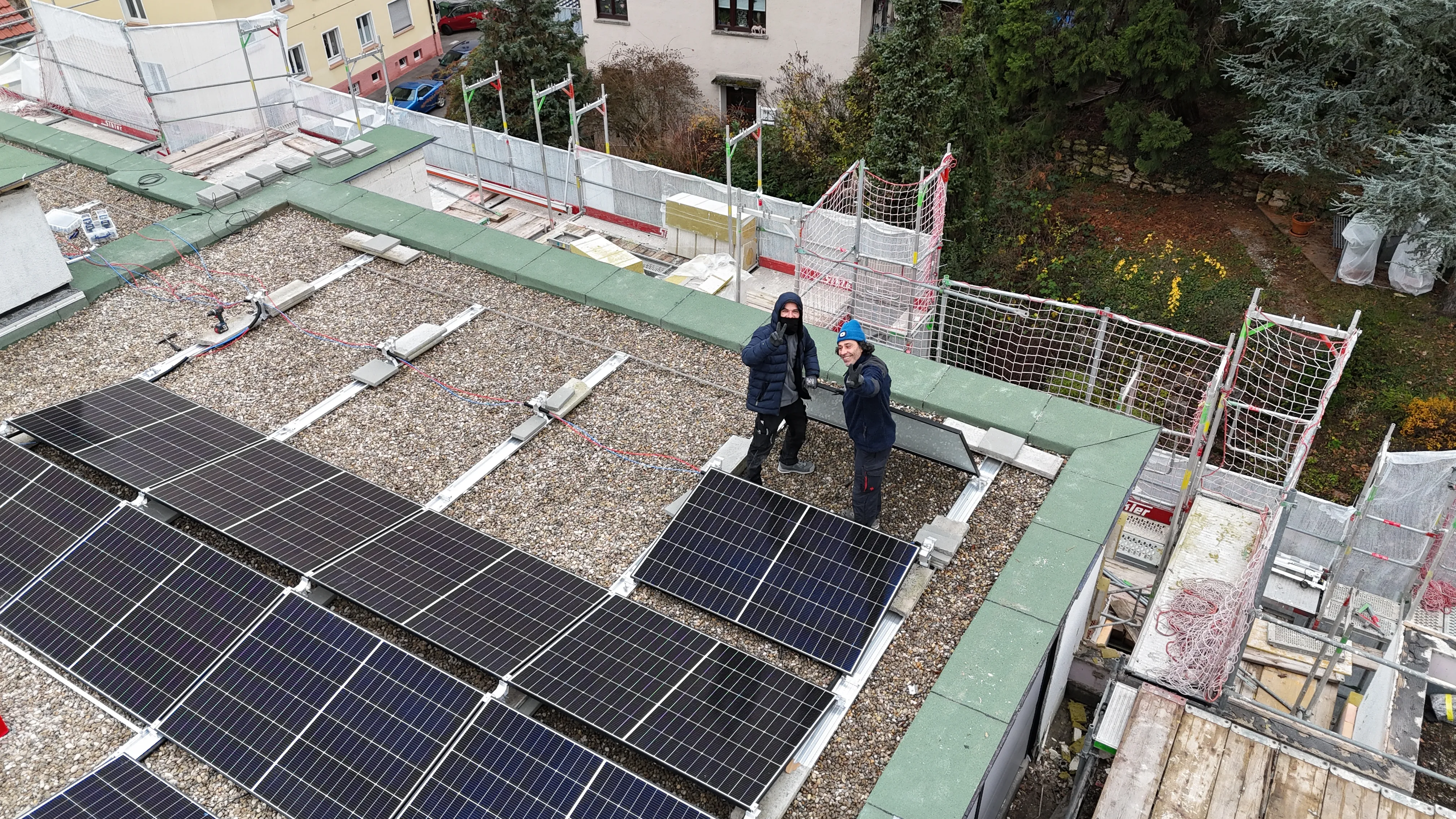 wokers of the Solarzentrum Stuttgart mounting PV modules on a rooftop solar plant
